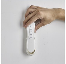 Main manipulant une télécommande pour contrôler un ventilateur