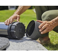 Un homme assemble une pompe de jardin à l''extérieur
