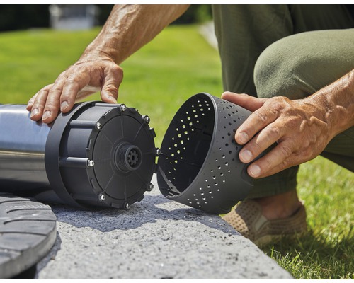 Un homme assemble une pompe de jardin à l''extérieur
