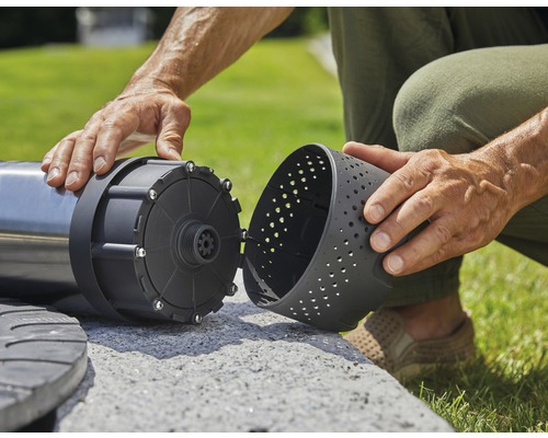 Eine Person montiert eine Wasserpumpe für den Gartenteich.