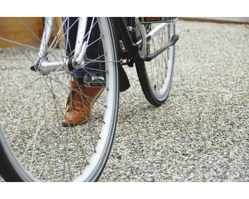 Gros plan d''un vélo avec une personne sur un sol de gravier