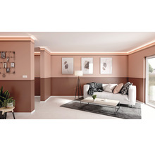Wohnzimmer mit Stuckprofilen und indirekter Beleuchtung an der Decke, mit Sofa, Tisch und Dekoration