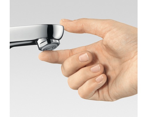 Nahaufnahme einer Hand, die den Auslauf eines Wasserhahns berührt.