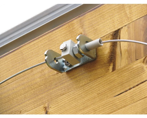 Vue détaillée d''un tendeur de câble métallique monté sur un mur en bois