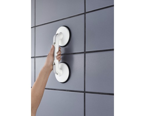Hand hält einen Saugnapf-Haltegriff an der Wand