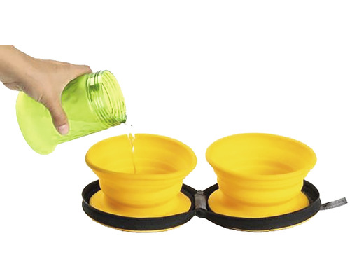 Zwei gelbe, faltbare Hundenäpfe werden mit Wasser aus einer Flasche befüllt.