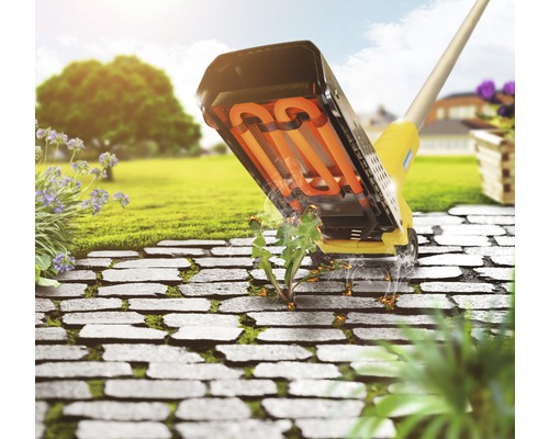 Désherbeur thermique en action sur une terrasse en pierre dans le jardin.