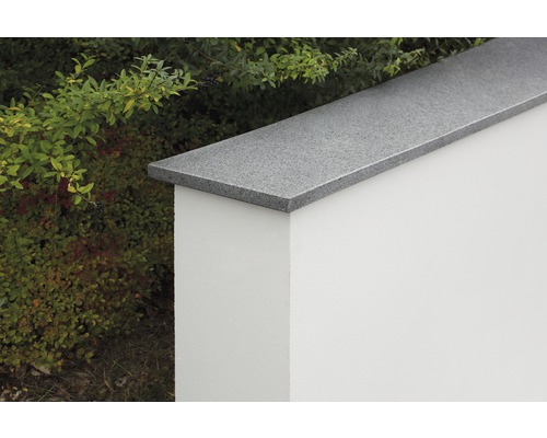 Mauerabdeckung aus Granit auf einer Gartenmauer