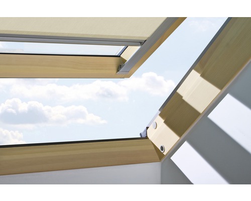 Fenêtre de toit ouverte avec store occultant et vue sur le ciel
