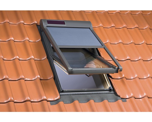 Fenêtre de toit ouverte avec protection solaire sur un toit en tuiles