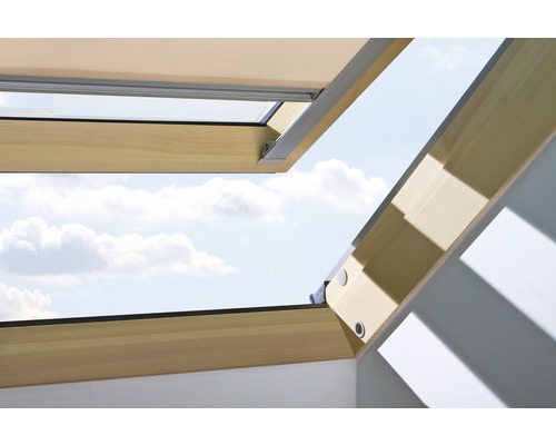 Fenêtre de toit ouverte avec cadre en bois et vue sur le ciel