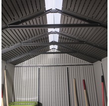 Vue intérieure d''un abri de jardin avec fenêtres de toit pour la ventilation et l''éclairage.