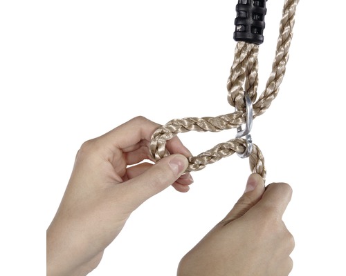 Les mains ajustent la longueur de la corde d''une balançoire.