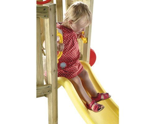 Fille glissant sur un toboggan de jeu en bois