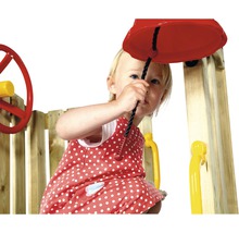 Enfant jouant avec une cloche sur une tour de jeu en bois