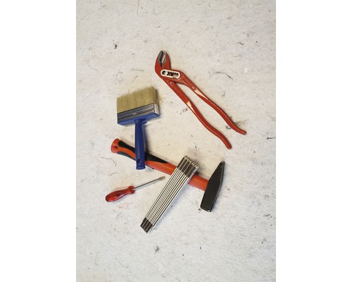 Verschiedene Werkzeuge, darunter Zange, Pinsel, Hammer, Schraubendreher und Zollstock.