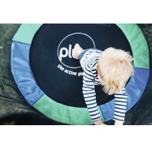 Enfant jouant sur un trampoline de jardin rond de la marque Plum