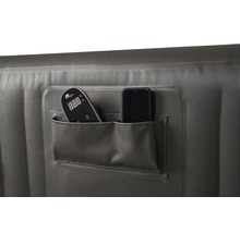 Détail d''un jacuzzi gonflable avec deux poches contenant une télécommande et un smartphone.