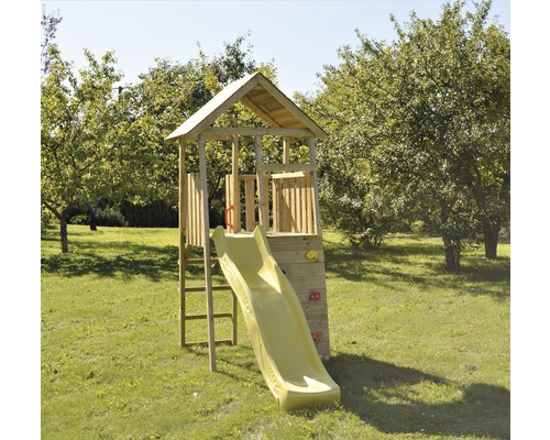 Spielturm mit Rutsche und Kletterwand auf einer Rasenfläche
