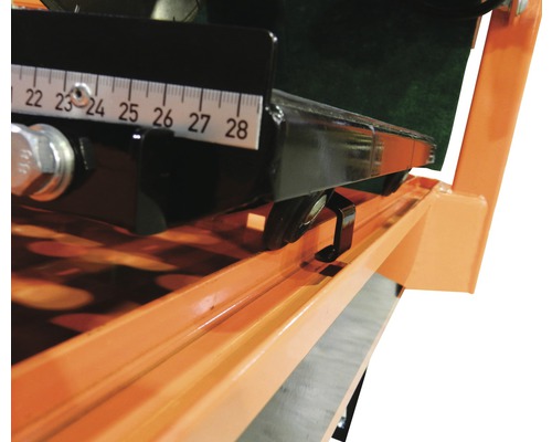 Vue détaillée d''une carreleuse avec une échelle de mesure pour un réglage précis de la largeur de coupe.