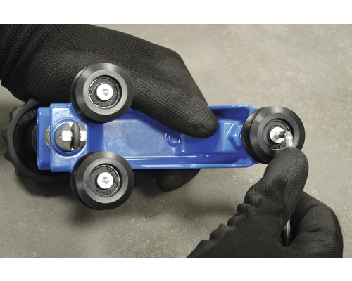 Blaue Werkzeugaufnahme mit schwarzen Rollen und Hand mit Werkzeughandschuh