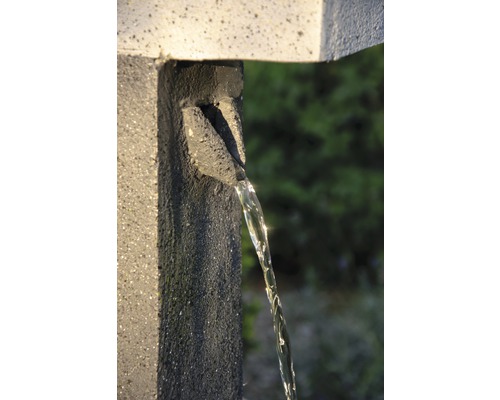 Wasserhahn aus Stein mit fließendem Wasser