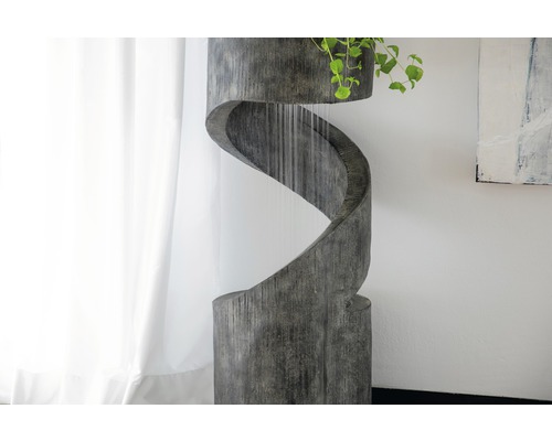 Dekorativer Zimmerbrunnen in Spiralform mit Pflanze