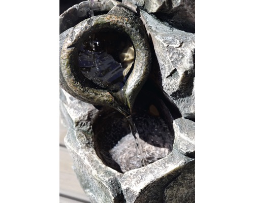 Vue détaillée d''une fontaine avec de l''eau qui coule sur des pierres