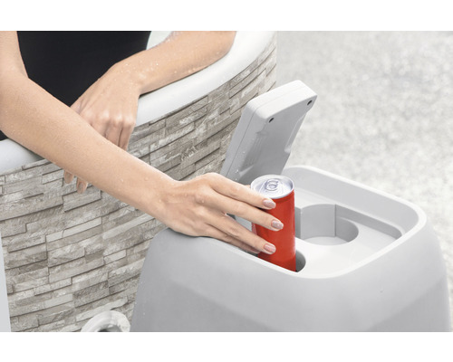 Frau legt Getränkedose in Kühlbox neben Badewanne