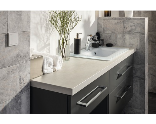 Meuble-lavabo de salle de bains avec lavabo, robinet et articles de décoration.