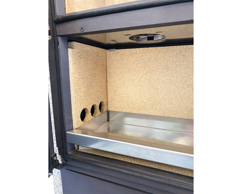 Innenraum eines Kaminofens mit Auskleidung, Luftlöchern und Aschelade