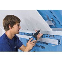 Handwerker befestigt eine Gipskartonplatte mit einem Akku-Schrauber an einer Unterkonstruktion.