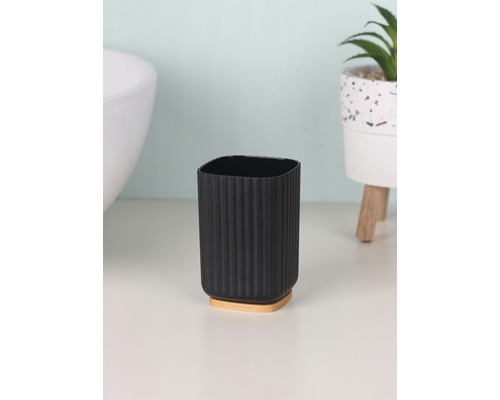 Gobelet à brosse à dents en plastique avec socle en bois dans salle de bains