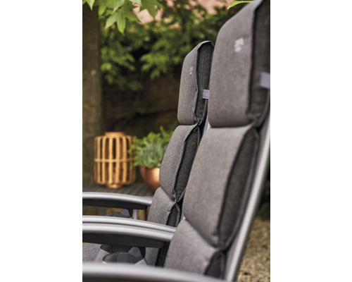 Gros plan de chaises de jardin avec coussins gris à l''extérieur.