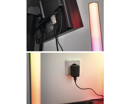 Detailaufnahme eines Monitors mit Kabelanschlüssen und einer Stehlampe sowie eines Netzteils in einer Steckdose