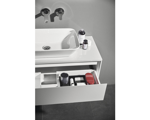 Modernes Badezimmer mit Waschbecken, Armaturen und geöffnetem Schubladenelement zur Aufbewahrung von Badutensilien