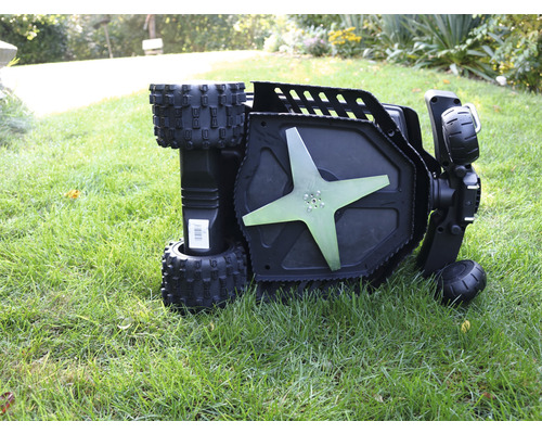 Ein Rasenmäher liegt auf dem Rasen und zeigt das Messer.