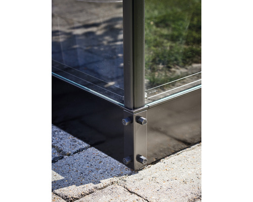 Gros plan d''une clôture en verre avec des raccords d''angle en métal sur des pavés