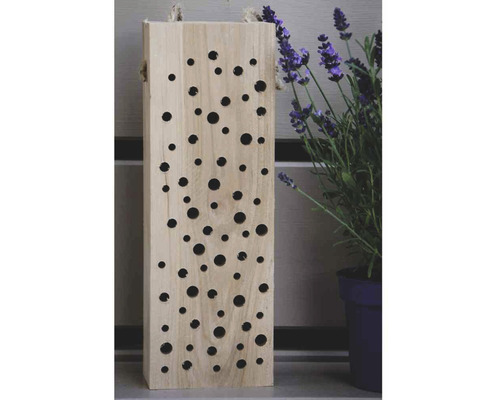 Insektenhotel aus Holz mit Löchern und Lavendelpflanze