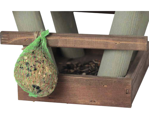 Boule de nourriture pour oiseaux dans un filet vert sur une mangeoire en bois