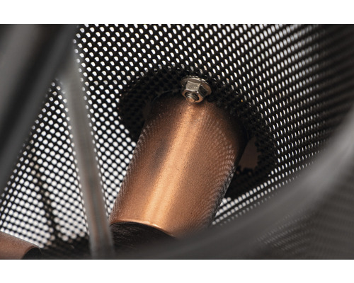 Gros plan d''une lampe avec un abat-jour en métal perforé et un boulon de fixation