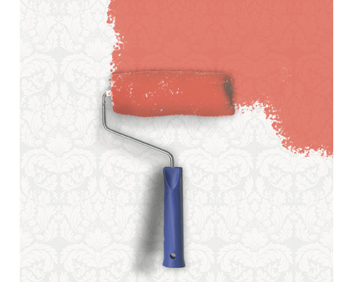 De la peinture est appliquée sur un mur à motifs avec un rouleau à peinture.