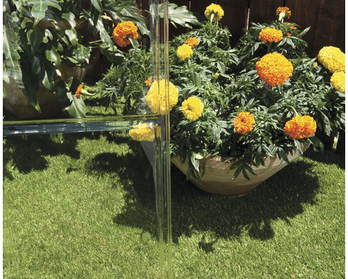 Szene mit Glaselementen, Blumen und Kunstrasen im Gartenbereich