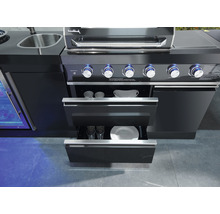Vue détaillée d''un barbecue d''extérieur noir avec des tiroirs ouverts contenant de la vaisselle