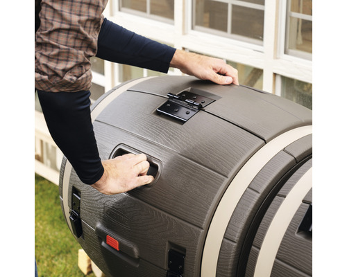 Regentonne in Fassoptik mit Deckel wird von einer Person geöffnet