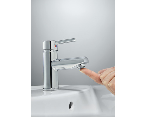 Einhebelmischer auf einem Waschbecken mit einem Finger, der den Strahlregler berührt.