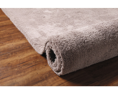 Tapis enroulé sur plancher en bois