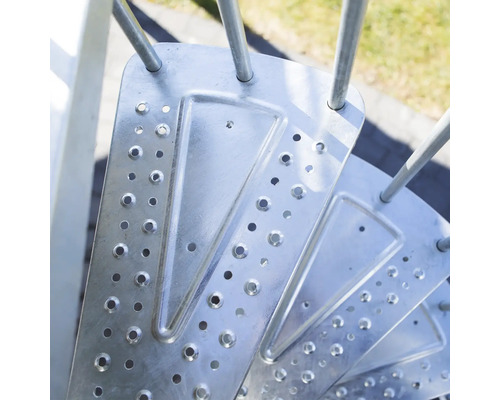 Detailaufnahme einer Wendeltreppe aus Metall mit Stufen mit Löchern.