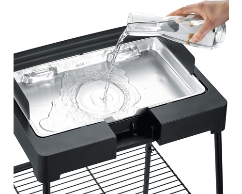 Wasser wird in eine elektrische Grillwanne gegossen