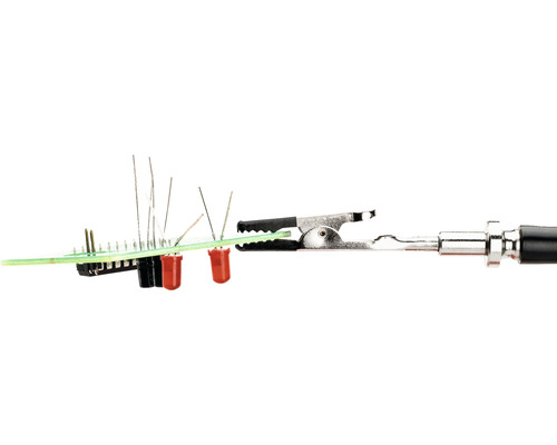 Composants électroniques sur une carte de circuit imprimé avec pince crocodile.